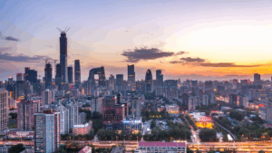 Skyline von Beijing mit Hochhäusern und dem markanten CCTV Tower im Sonnenuntergang.
