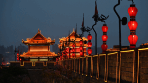 Beleuchtete Stadtmauer von Xi’an am Abend mit roten Laternen und traditioneller chinesischer Architektur.