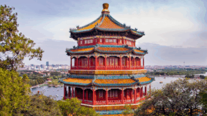 Mehrstöckige rote Pagode im Sommerpalast von Beijing mit Blick auf den Kunming-See und die Stadt im Hintergrund.