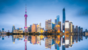 Skyline von Shanghai mit Oriental Pearl Tower, modernen Wolkenkratzern und Spiegelung im Fluss.